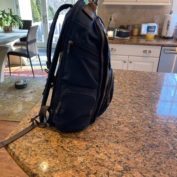 Tumi blue and black backpack. All zips & interior excellent. Two small spots.